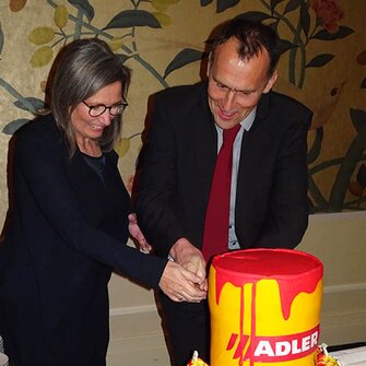 Generální ředitelka společnosti ADLER krájí společně s jednatelem ADLER Česko žlutý dort ve tvaru tradiční plechovky.